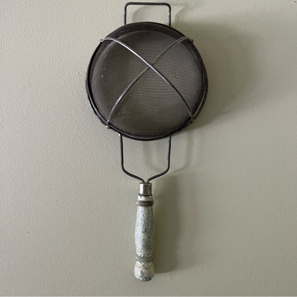 Antique strainer with wooden handle.